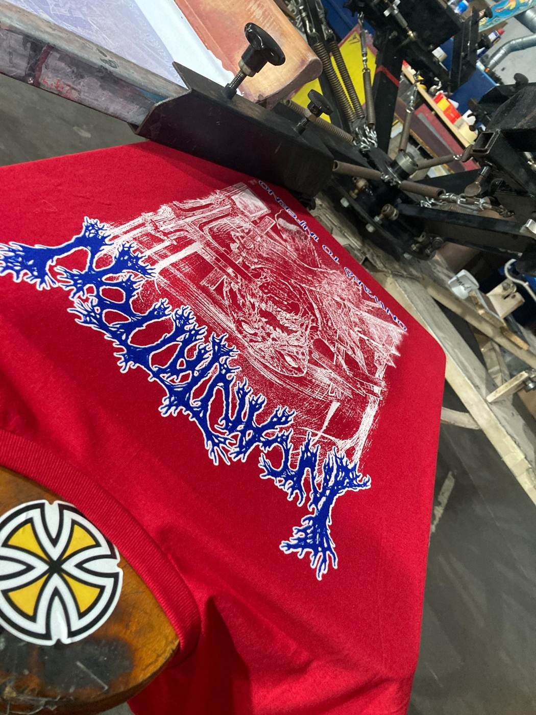 Red metal band T-shirt being printed on a professional press