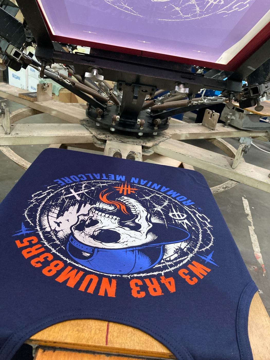 Kraken screen printing press producing a custom metal band T-shirt