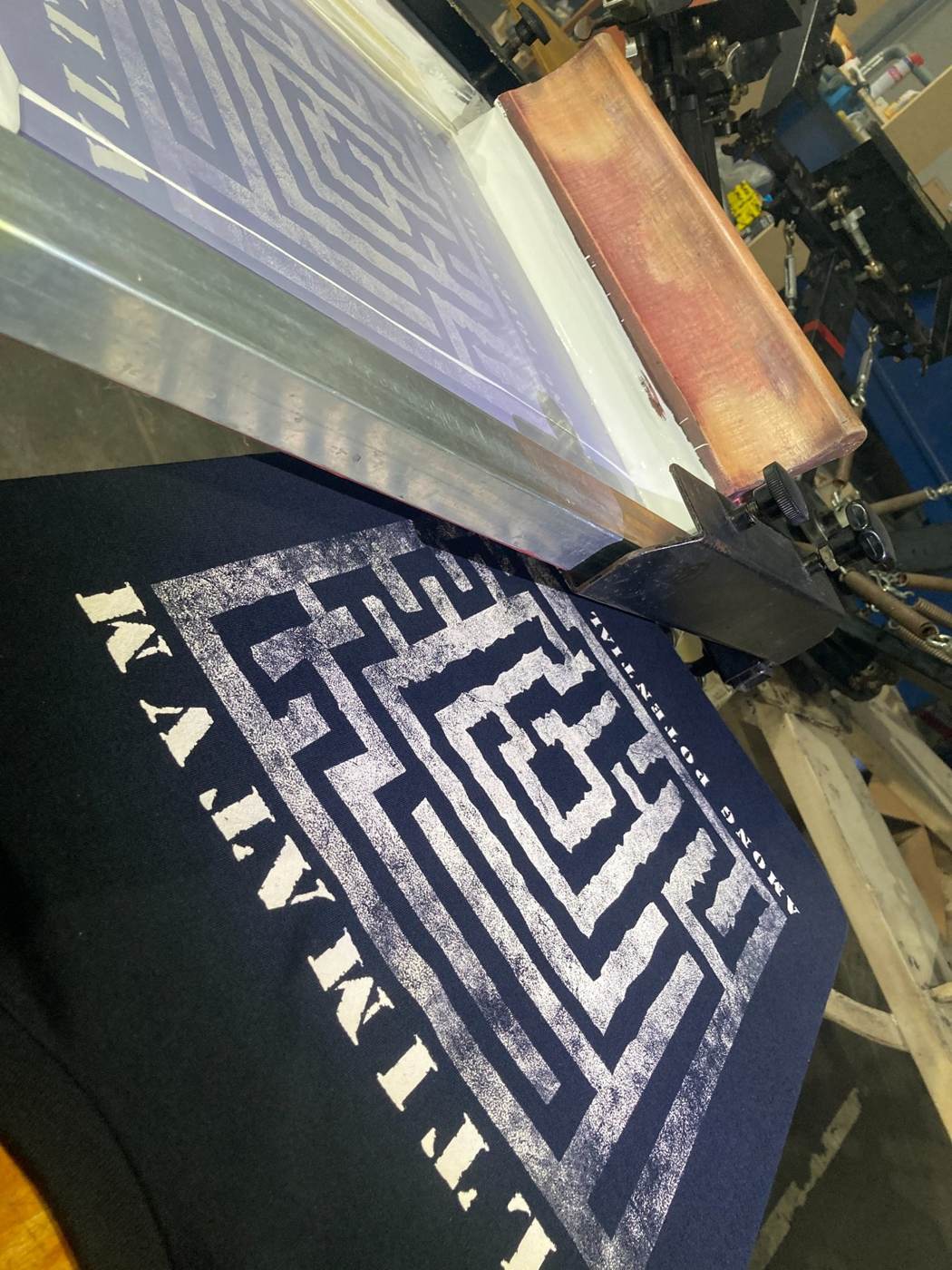 Close-up of water-based screen printing on black band merchandise