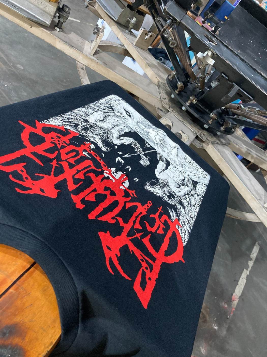 Red and white screen print on black metal band merchandise